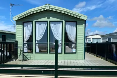a green gazebo with white curtains on a deck at Beachside Lodge - Sleeps 6 - Pets ok - Parking in Morecambe