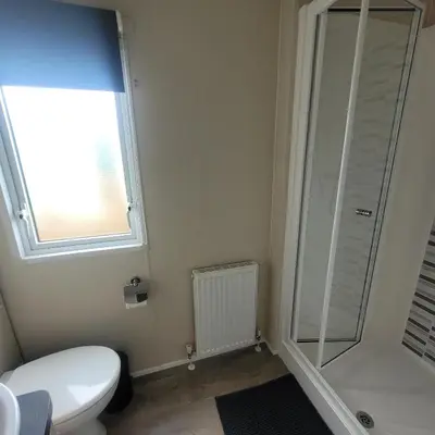 a bathroom with a toilet and a shower and a window at Beachside Lodge - Sleeps 6 - Pets ok - Parking in Morecambe