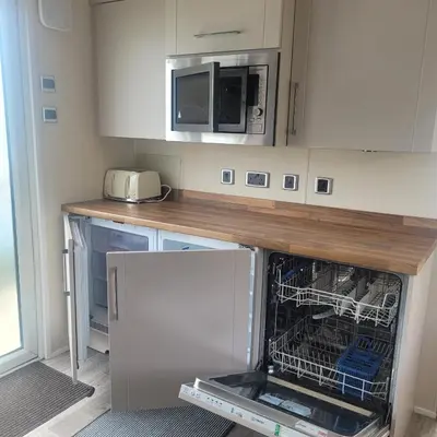 an open dishwasher in a kitchen with a microwave at Beachside Lodge - Sleeps 6 - Pets ok - Parking in Morecambe