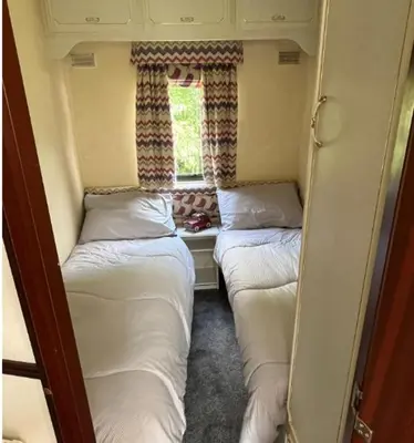 three beds in a small room with a window at Hare Meadow Lodge in Mellor