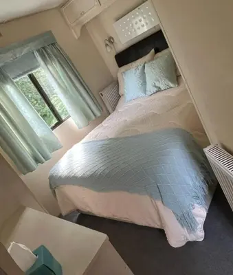 a bedroom with a large bed and a window at Hare Meadow Lodge in Mellor