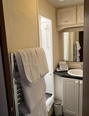 a bathroom with a sink and towels in it at Hare Meadow Lodge in Mellor