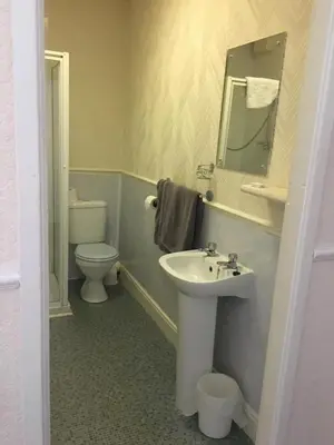 a bathroom with a sink and a toilet and a mirror at Walford Hotel in Blackpool