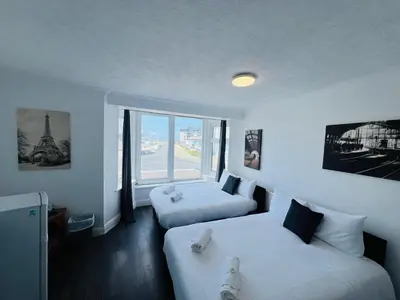 a hotel room with two beds and a window at Henson hotel in Blackpool