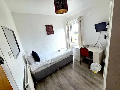 a bedroom with a bed and a desk with a computer at Henson hotel in Blackpool