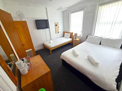a hotel room with a large bed and a table at Henson hotel in Blackpool