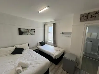 a small room with two beds and a window at Henson hotel in Blackpool