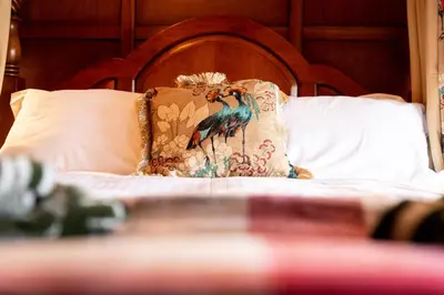 a pillow with a peacock on it on a bed at The Kings Arms in Cartmel