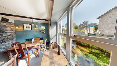 a dining room with a table and a large window at The Kings Arms in Cartmel