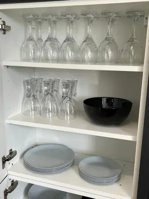 a shelf with wine glasses and plates on it at MOREaccom Maisonette in Morecambe