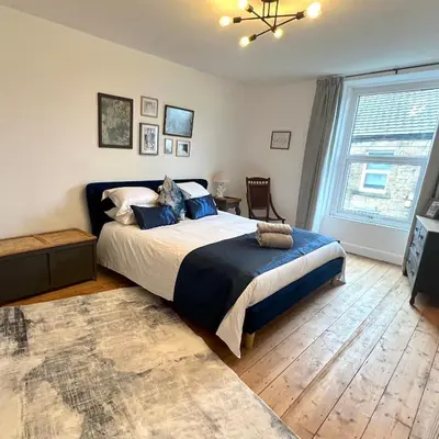 a bedroom with a bed and a large window at MOREaccom Maisonette in Morecambe