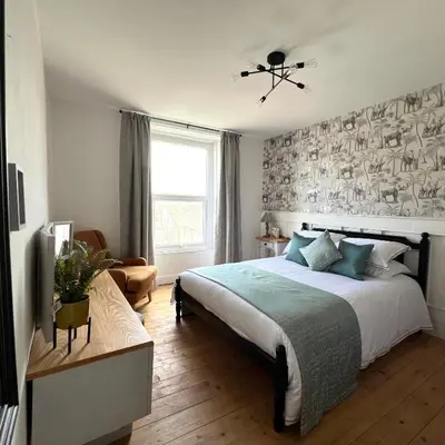 a bedroom with a large bed and a window at MOREaccom Maisonette in Morecambe