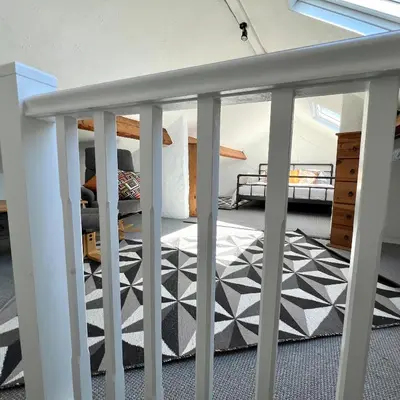 a room with a balcony with a black and white rug at MOREaccom Maisonette in Morecambe