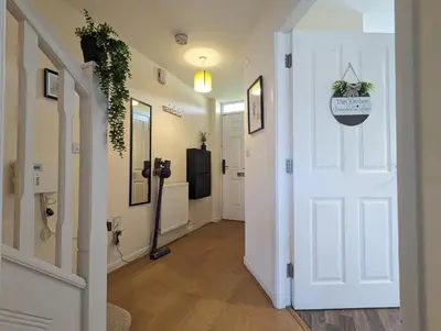 a hallway with a white door and a television at Large 4-Bedrooms House Near Centre Free Parking in Liverpool