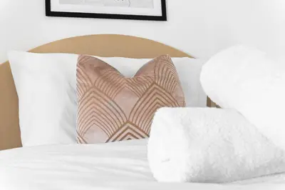 a bed with two pillows on it with at Anfield Four-Bed Spacious Getaway Haus in Liverpool