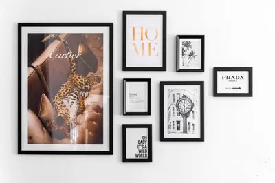 a group of framed pictures on a wall at Anfield Four-Bed Spacious Getaway Haus in Liverpool