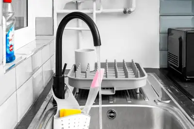 a kitchen with a sink with a dish drying rack at Anfield Four-Bed Spacious Getaway Haus in Liverpool
