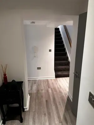 a hallway with a staircase with a chair and a piano at 5 Halifax House, apartment 3 in Liverpool