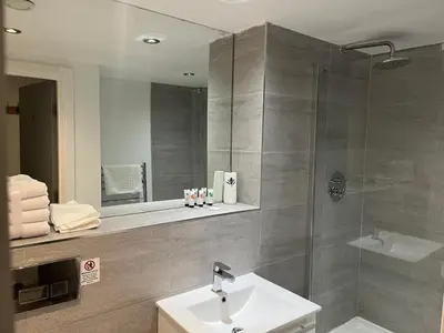 a bathroom with a shower and a sink and a mirror at 5 Halifax House, apartment 3 in Liverpool
