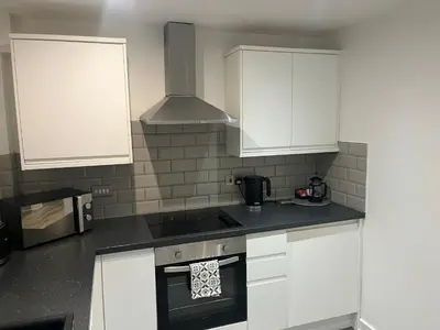 a kitchen with white cabinets and a stove top oven at 5 Halifax House, apartment 3 in Liverpool