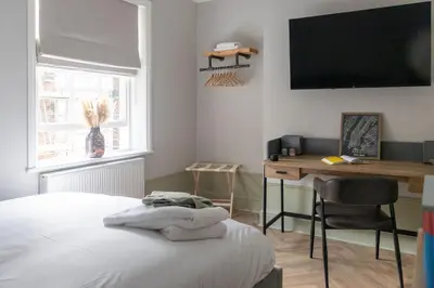 a bedroom with a bed and a desk and a television at No 45 Roscoe St in Liverpool