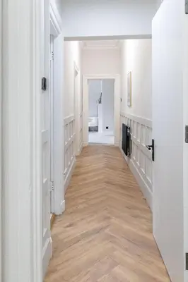 a hallway of a home with white walls and wood floors at No 45 Roscoe St in Liverpool
