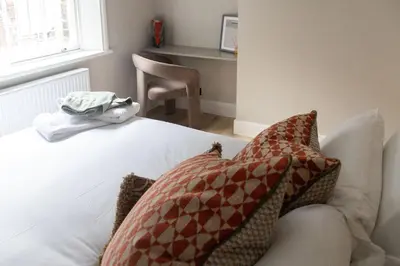 a bedroom with a bed with pillows and a desk at No 45 Roscoe St in Liverpool