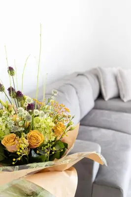 a bouquet of flowers on a table in front of a couch at No 45 Roscoe St in Liverpool