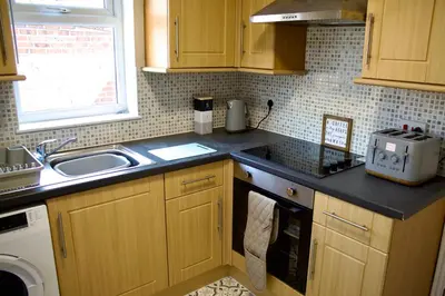 a kitchen with a sink and a counter top at Spacious Flats in St Helens, Merseyside in Saint Helens