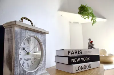 a clock sitting on top of a stack of books at Spacious Flats in St Helens, Merseyside in Saint Helens