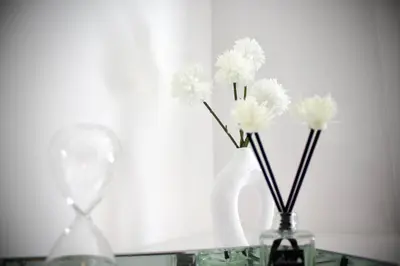 two vases with white flowers sitting on a table at Spacious Flats in St Helens, Merseyside in Saint Helens