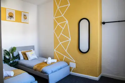 a room with a bed and a mirror on the wall at Large 4-Bedroom House, 6 Beds, Comfortable Home-from-Home, Great Deals in Wallasey