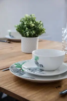 a cup and a plate on a wooden table with a plant at Large 4-Bedroom House, 6 Beds, Comfortable Home-from-Home, Great Deals in Wallasey