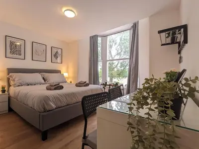 a bedroom with a bed and a table and a window at Room Near City Centre Private Bath Free Parking in Liverpool