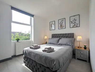 a bedroom with a large bed with two towels on it at Room Near City Centre Private Bath Free Parking in Liverpool