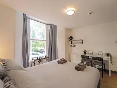 a bedroom with a bed and a desk and a window at Room Near City Centre Private Bath Free Parking in Liverpool