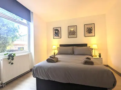 a bedroom with a large bed with two lamps and a window at Room Near City Centre Private Bath Free Parking in Liverpool