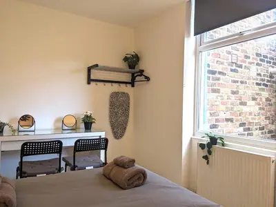 a teddy bear sitting on a bed in a bedroom at Room Near City Centre Private Bath Free Parking in Liverpool