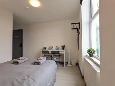 a bedroom with a bed and a table and a window at Room Near City Centre Private Bath Free Parking in Liverpool