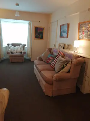 a living room with a couch and a window at Marjorie's Cottage in Ulverston