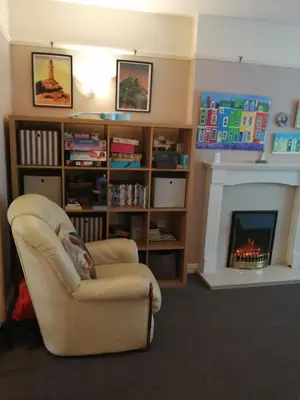 a living room with a chair and a fireplace at Marjorie's Cottage in Ulverston
