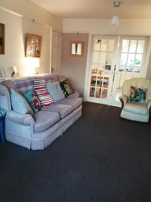 a living room with a couch and two chairs at Marjorie's Cottage in Ulverston