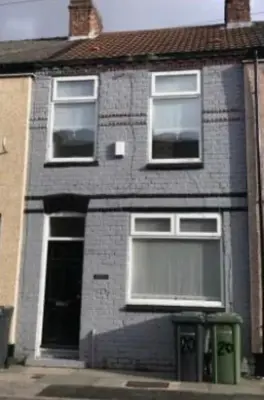a brick house with three windows and a garbage can at Residency serviced accomodation liverpool in Litherland