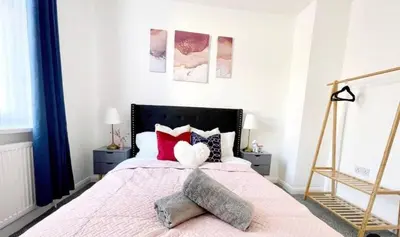 a bedroom with a pink bed with two pillows at Residency serviced accomodation liverpool in Litherland