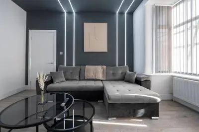 a living room with a couch and a glass table at Cozy Modern Home Games Room & Cinema Perfect for 8 in Bolton