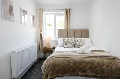 a bedroom with a large bed and a window at Cozy Modern Home Games Room & Cinema Perfect for 8 in Bolton