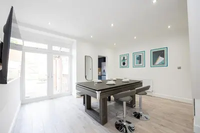 a dining room with a table and two chairs at Cozy Modern Home Games Room & Cinema Perfect for 8 in Bolton