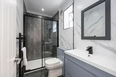 a bathroom with a shower and a toilet and a sink at Cozy Modern Home Games Room & Cinema Perfect for 8 in Bolton