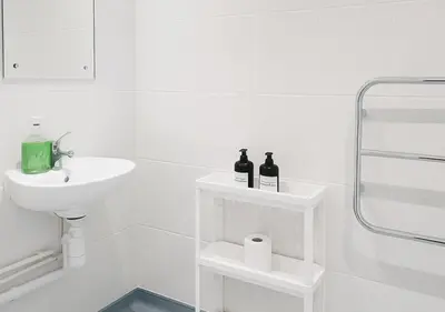 a white bathroom with a sink and two bottles of wine at Manhattan Suites Near Liverpool ONE sleeps 4 in Liverpool