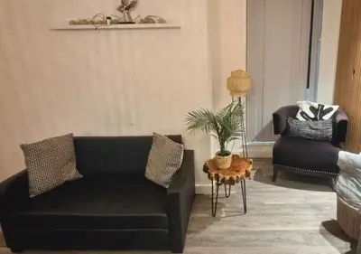 a living room with a black couch and a chair at Manhattan Suites Near Liverpool ONE sleeps 4 in Liverpool